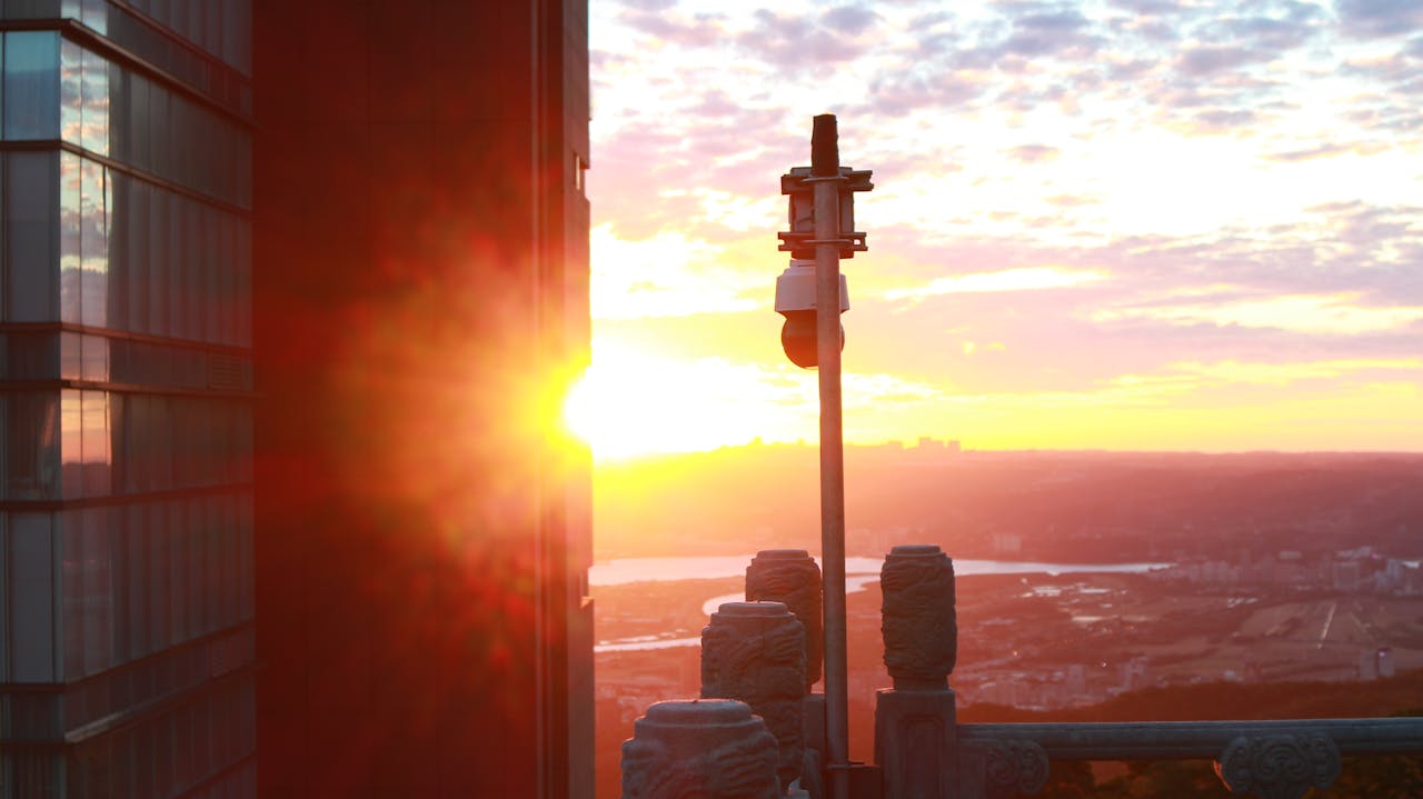 digital-01 A breathtaking cityscape view at sunset with striking sunflare and modern architecture.